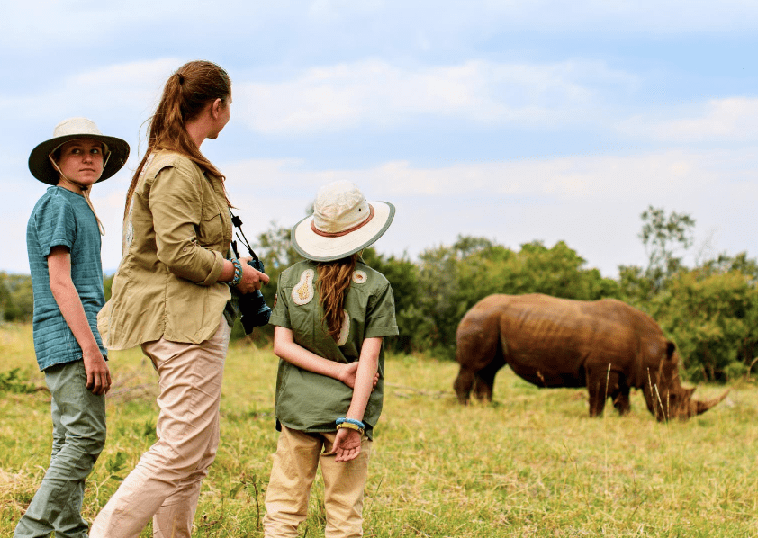 A family on a guided safari adventure observing rhinos in a South African game reserve, one of the exclusive activities offered as an add-on package to the 2025 International Pairs World Final.